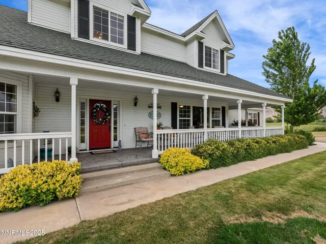 a view of two chairs in the balcony next to a yard