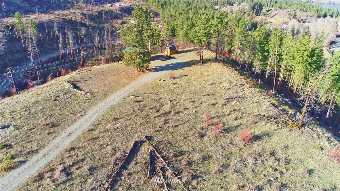 1 Rising Eagle Road, Unit RD Twisp, WA 98856 - Photo 29 of 40 a backyard of a house with large trees and covered with wooden fence