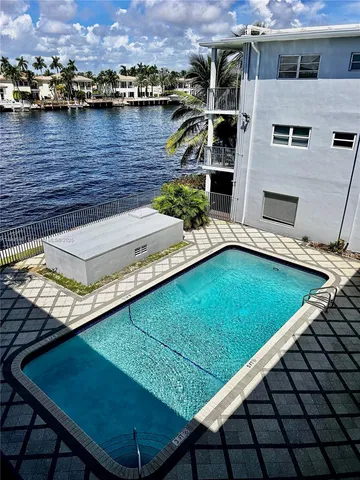 an aerial view of a house with a swimming pool and a yard