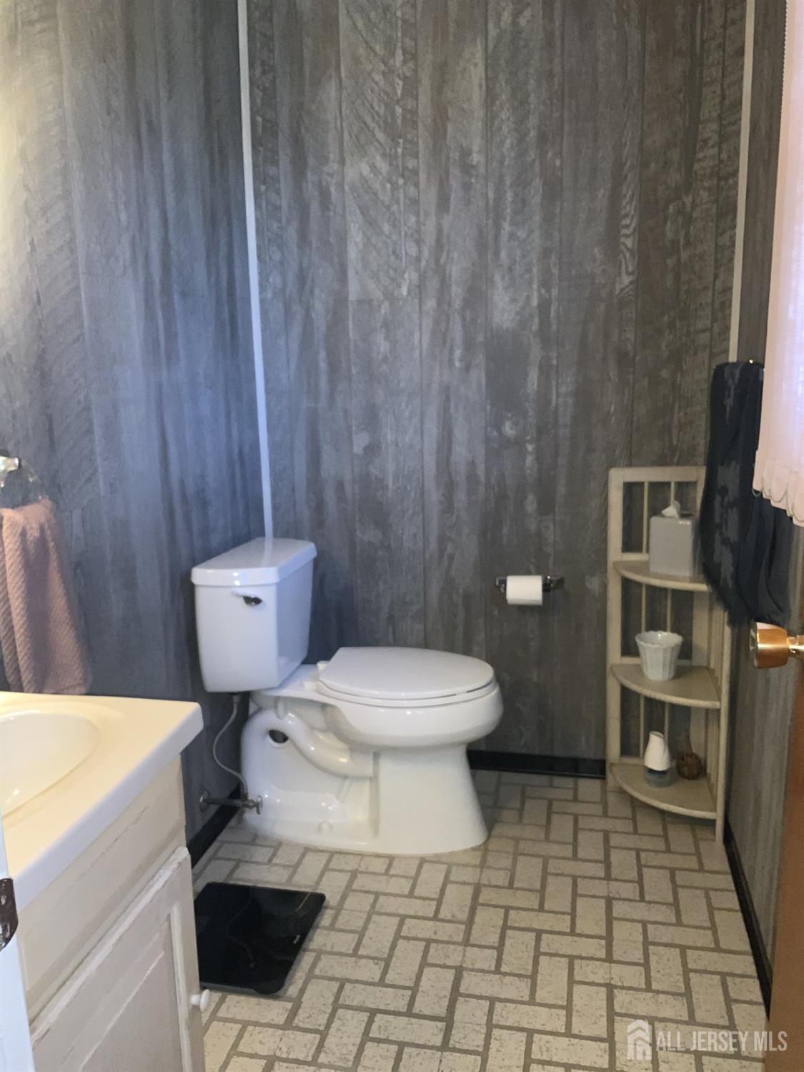 178 Willow Street Port Reading, NJ 07064 - Photo 9 of 15 a white toilet sitting next to a white sink and vanity