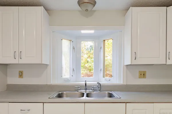 a kitchen with stainless steel appliances granite countertop a sink and a white cabinets