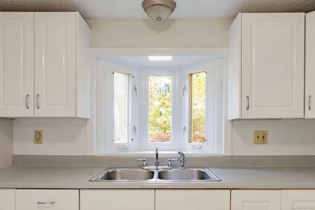 a kitchen with stainless steel appliances granite countertop a sink and a white cabinets