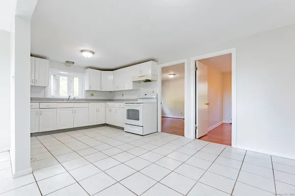 a kitchen with white cabinets and white appliances