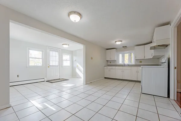 a view of a kitchen with white cabinets and white appliances