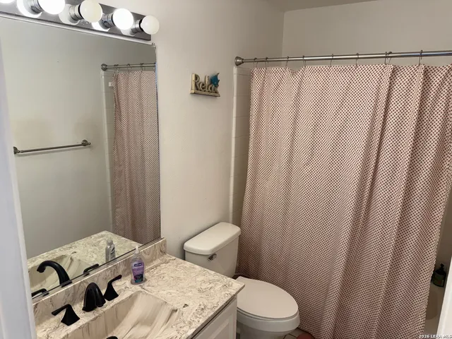 a view of a hallway with wooden floor and cabinet