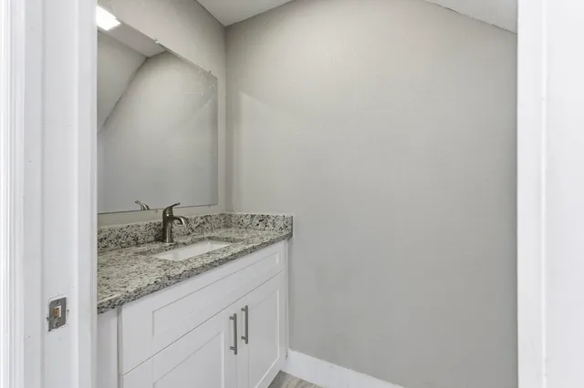 a bathroom with a granite countertop sink and vanity