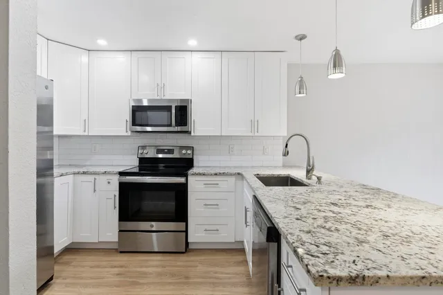 a kitchen with granite countertop a stove and a sink