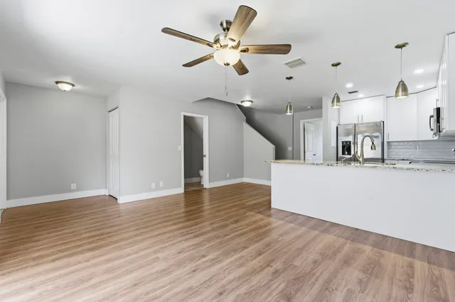 a view of a kitchen with wooden floor and a ceiling fan
