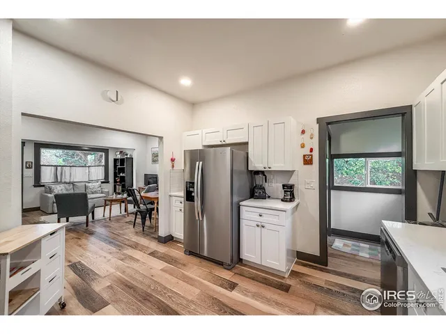 a open kitchen with refrigerator stove dining table and chairs
