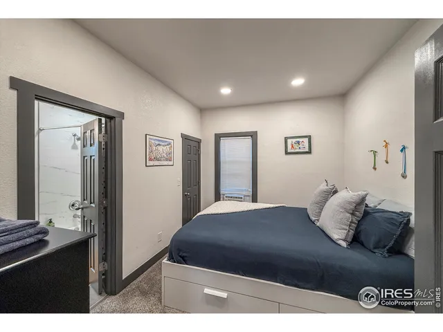 a bedroom with a bed and a large mirror