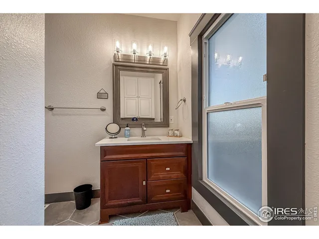 a bathroom with a sink a light fixture and a glass door