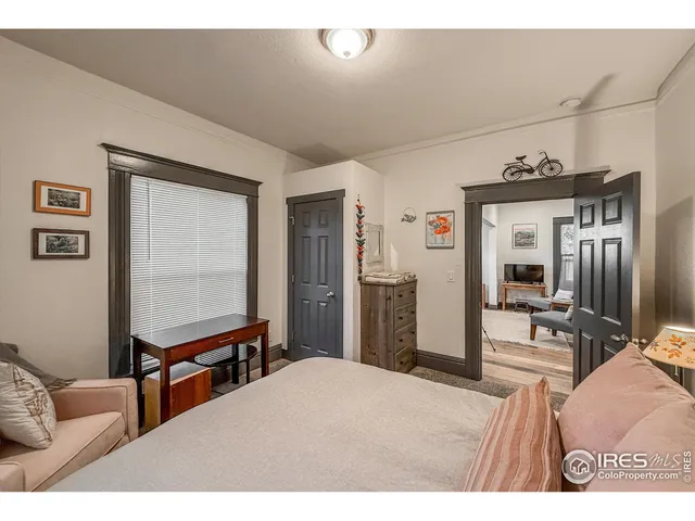 a bedroom with a bed window and mirror