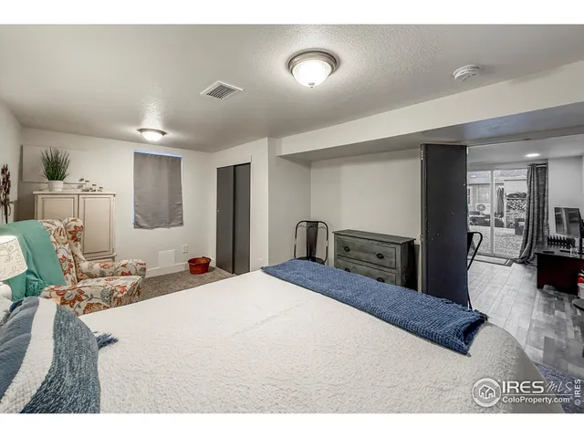 a large bedroom with a bed and a view of kitchen