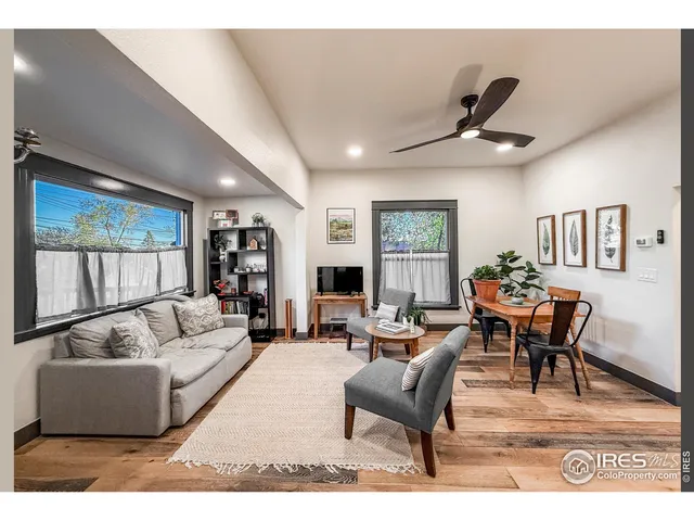a living room with furniture wooden floor and a large window