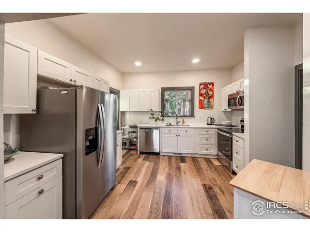a kitchen with a refrigerator sink and cabinets