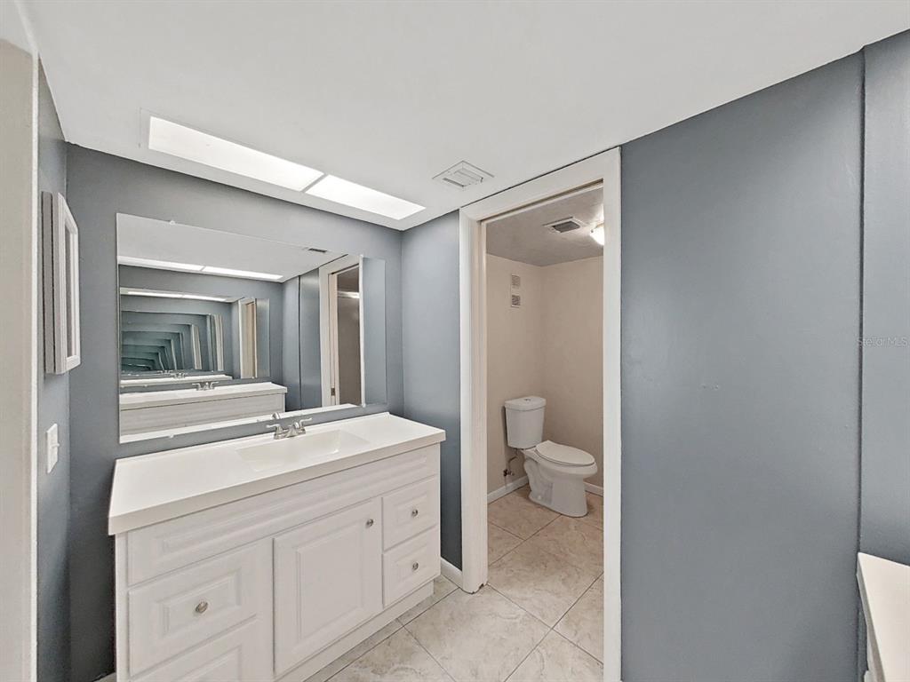 700 Starkey Road, Unit 624 Largo, FL 33771 - Photo 15 of 24 a bathroom with a toilet a sink and mirror
