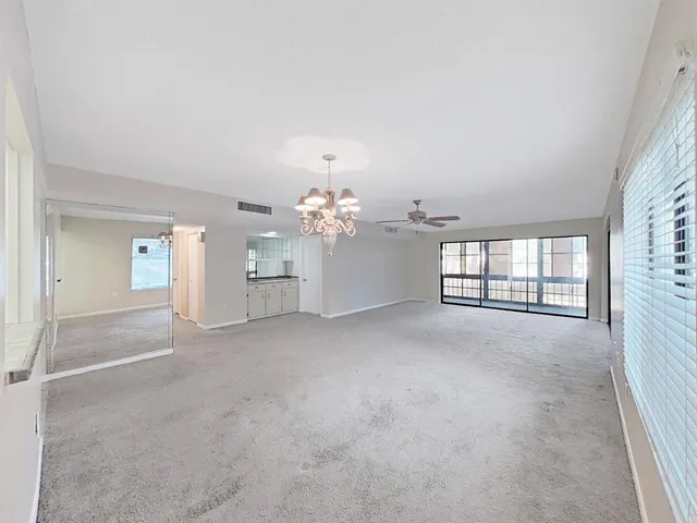 a view of a big room with windows and chandelier