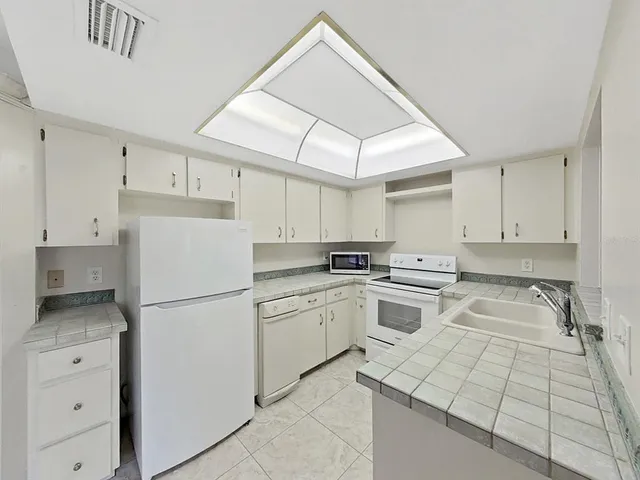 a kitchen with white cabinets and white appliances
