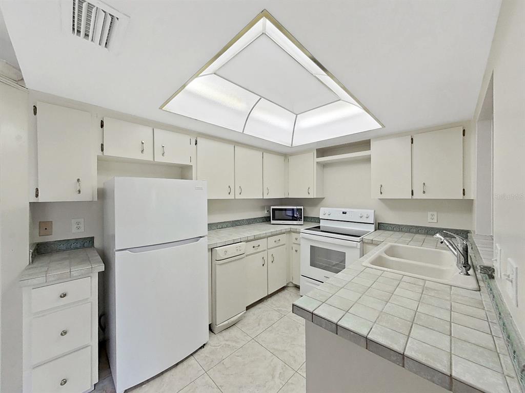 700 Starkey Road, Unit 624 Largo, FL 33771 - Photo 9 of 24 a kitchen with white cabinets and white appliances