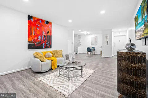 a living room with furniture and a painting on the wall
