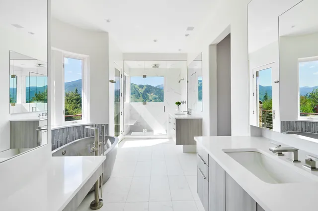 a spacious bathroom with a tub sink and mirror