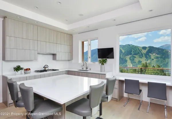 a kitchen with a table chairs microwave and cabinets