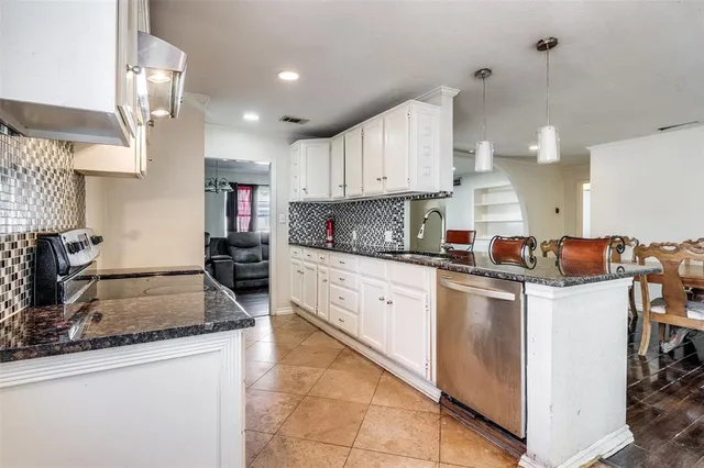 a kitchen with kitchen island granite countertop a sink counter top space appliances and cabinets