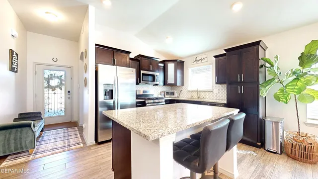 a living room with furniture kitchen view and a large window
