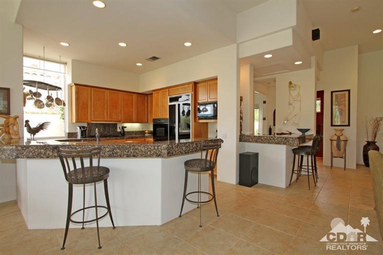 178 Loch Lomond Road Rancho Mirage, CA 92270 - Photo 14 of 32 a kitchen with stainless steel appliances kitchen island granite countertop a stove a sink a refrigerator and a dining table