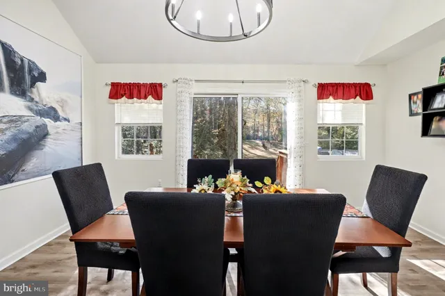 a dining room with furniture a livingroom view and wooden floor