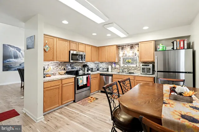 a kitchen with stainless steel appliances granite countertop a stove refrigerator and a sink