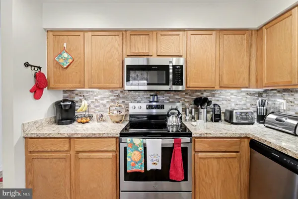 a kitchen with granite countertop a sink stove and cabinets