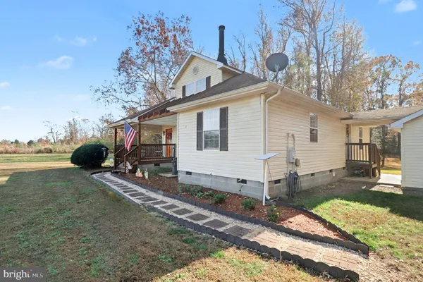 a view of a house with backyard and trees