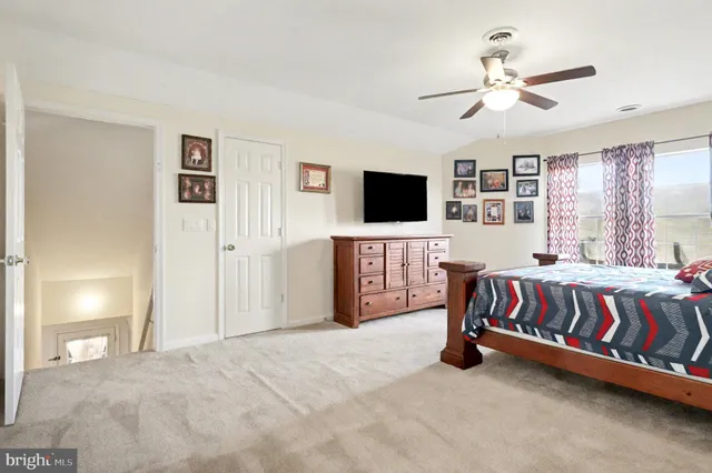 a spacious bedroom with a bed and a flat screen tv