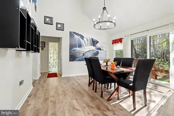 a dining room with furniture a chandelier and wooden floor