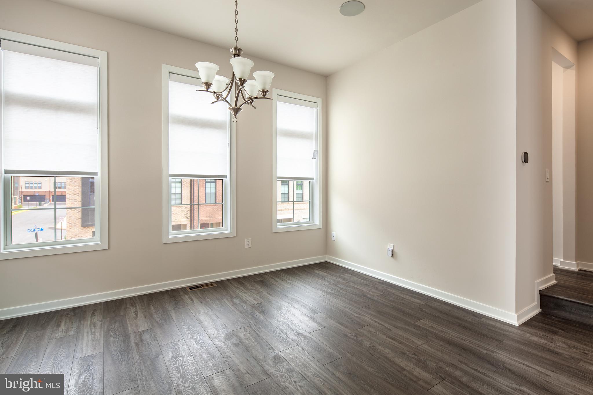 1770 Violet Ridge Place McLean, VA 22102 - Photo 22 of 54 an empty room with wooden floor chandelier and windows