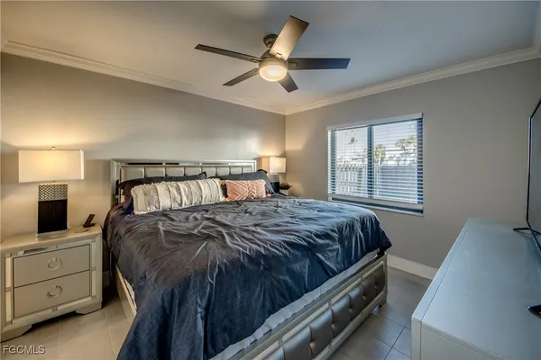 a spacious bedroom with a large bed and a flat screen tv