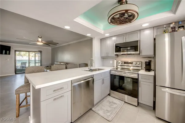 a kitchen with stainless steel appliances a table chairs and a refrigerator