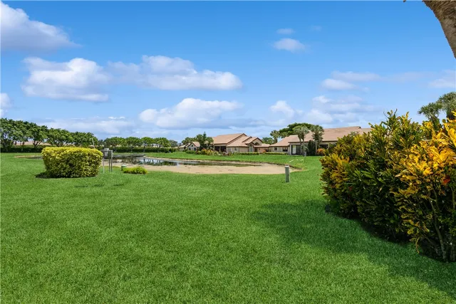 a view of a green field with house in the background