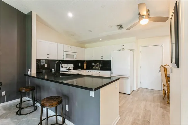 a kitchen with stainless steel appliances granite countertop a sink a stove and a refrigerator