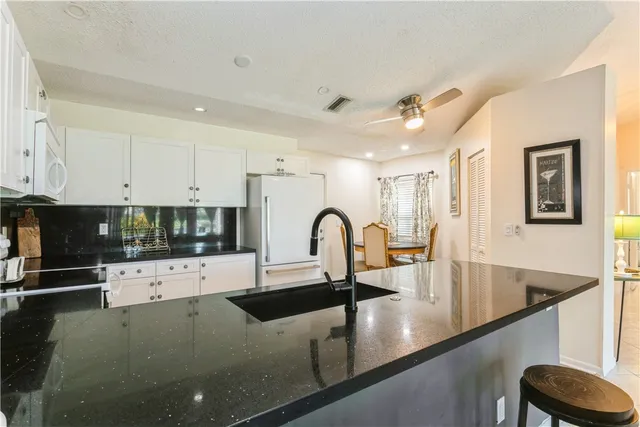 a view of a kitchen with kitchen island a sink stainless steel appliances and cabinets