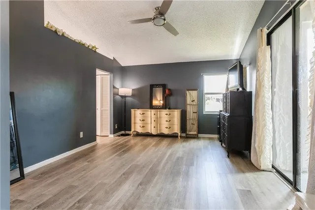 a view of a kitchen with a refrigerator a stove top oven and wooden floor