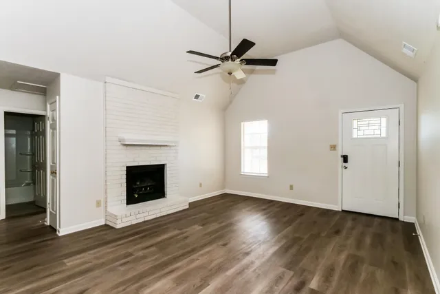 a view of empty room with wooden floor and fireplace