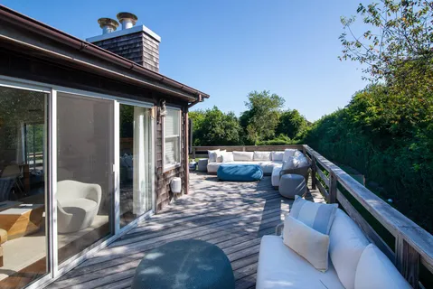 a view of deck with furniture and trees