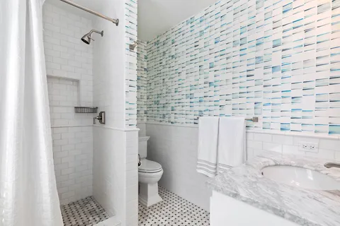 a bathroom with a granite countertop bathtub and toilet