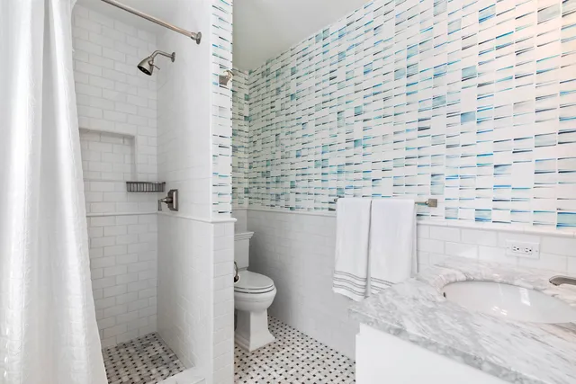 a bathroom with a granite countertop bathtub and toilet