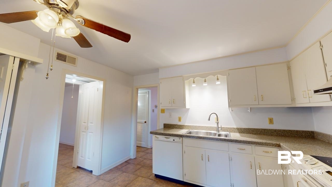 4009 Old Shell Road, Unit C13 Mobile, AL 36608 - Photo 12 of 32 Kitchen with white dishwasher, a sink, a ceiling fan, light tile patterned floors, and white cabinetry