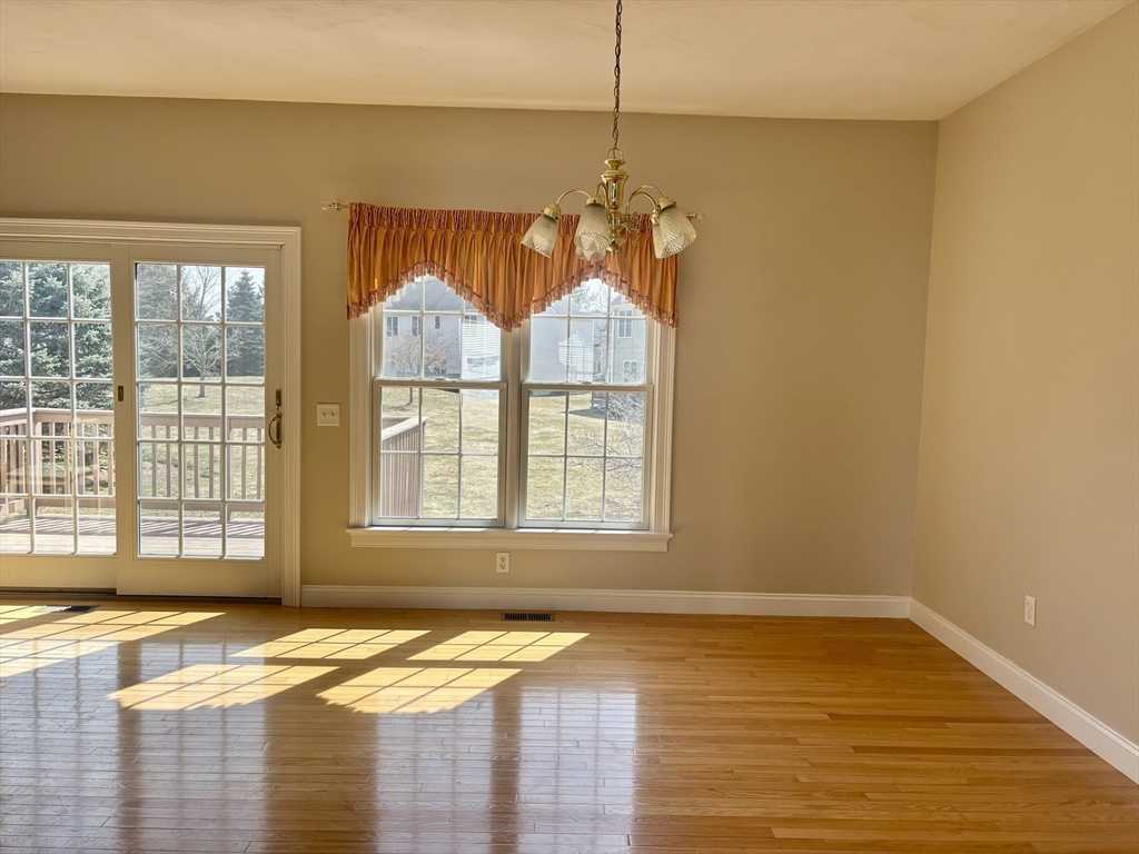 36 Knowlton Circle, Unit 1 Upton, MA 01568 - Photo 12 of 37 a view of an empty room with a window and wooden floor