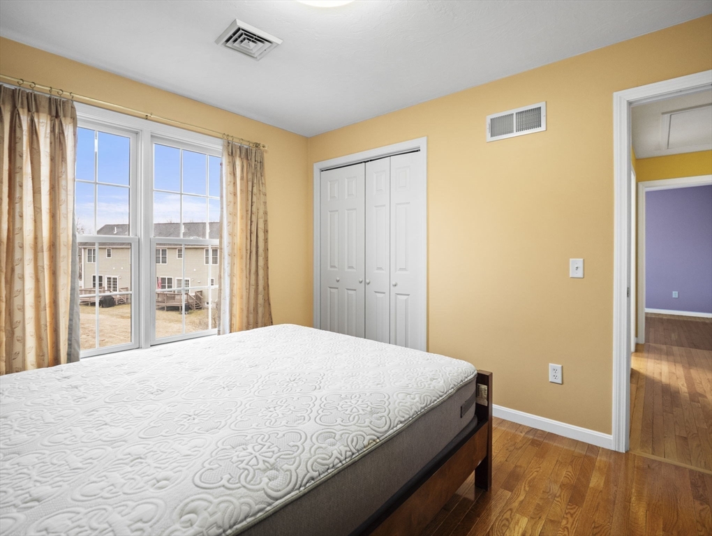 36 Knowlton Circle, Unit 1 Upton, MA 01568 - Photo 29 of 37 a bedroom with a bed and wooden floor