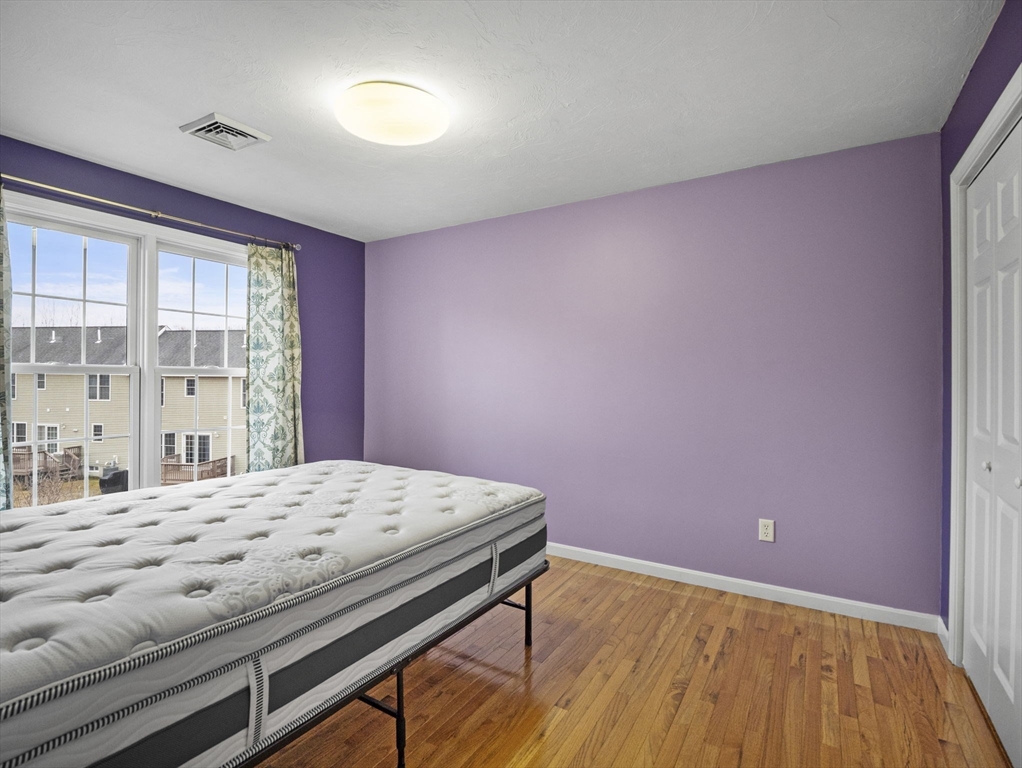 36 Knowlton Circle, Unit 1 Upton, MA 01568 - Photo 35 of 37 a bedroom with a bed and a dresser next to a window